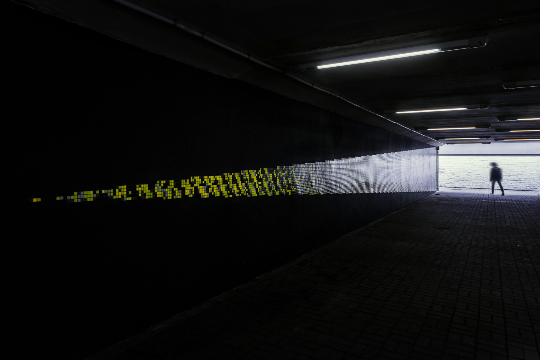 Mural w przejściu podziemnym zielone rozchodzące się fale dźwięku na czarnym tle Trufle Mozaiki